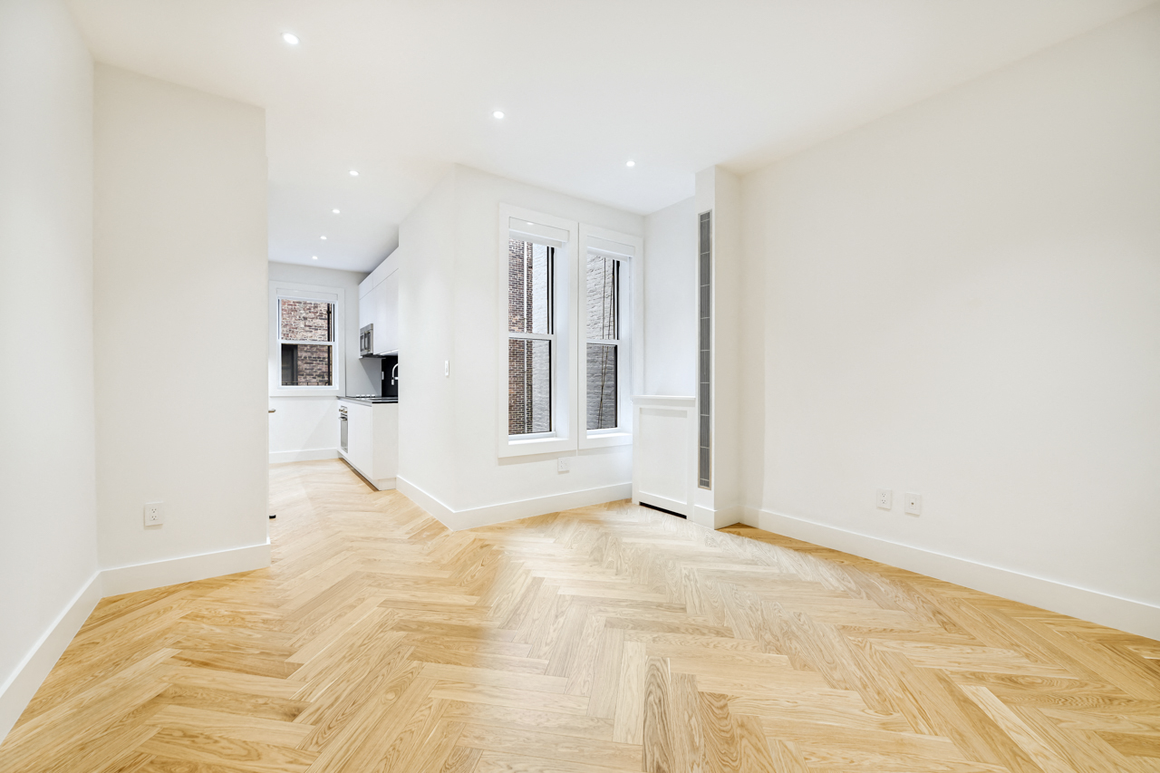 a living room with a hard wood floor and white walls